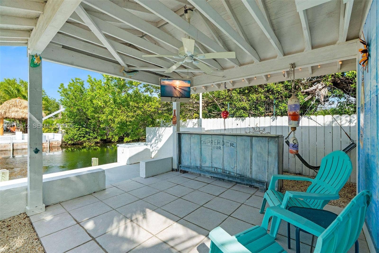 Key Largo, FL 33037 Covered outdoor patio featuring tile flooring, a built-in bar, a ceiling fan, and direct water frontage