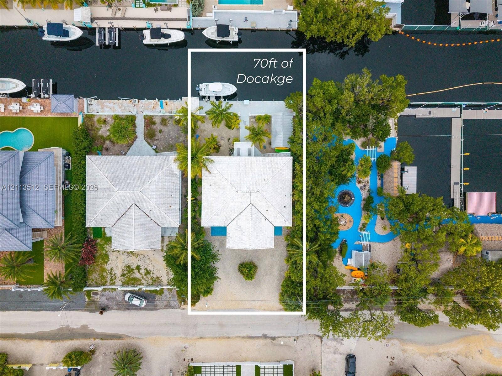 Key Largo, FL 33037 Aerial perspective of a waterfront property featuring 70 feet of canal frontage, a private boat dock, and mature palms