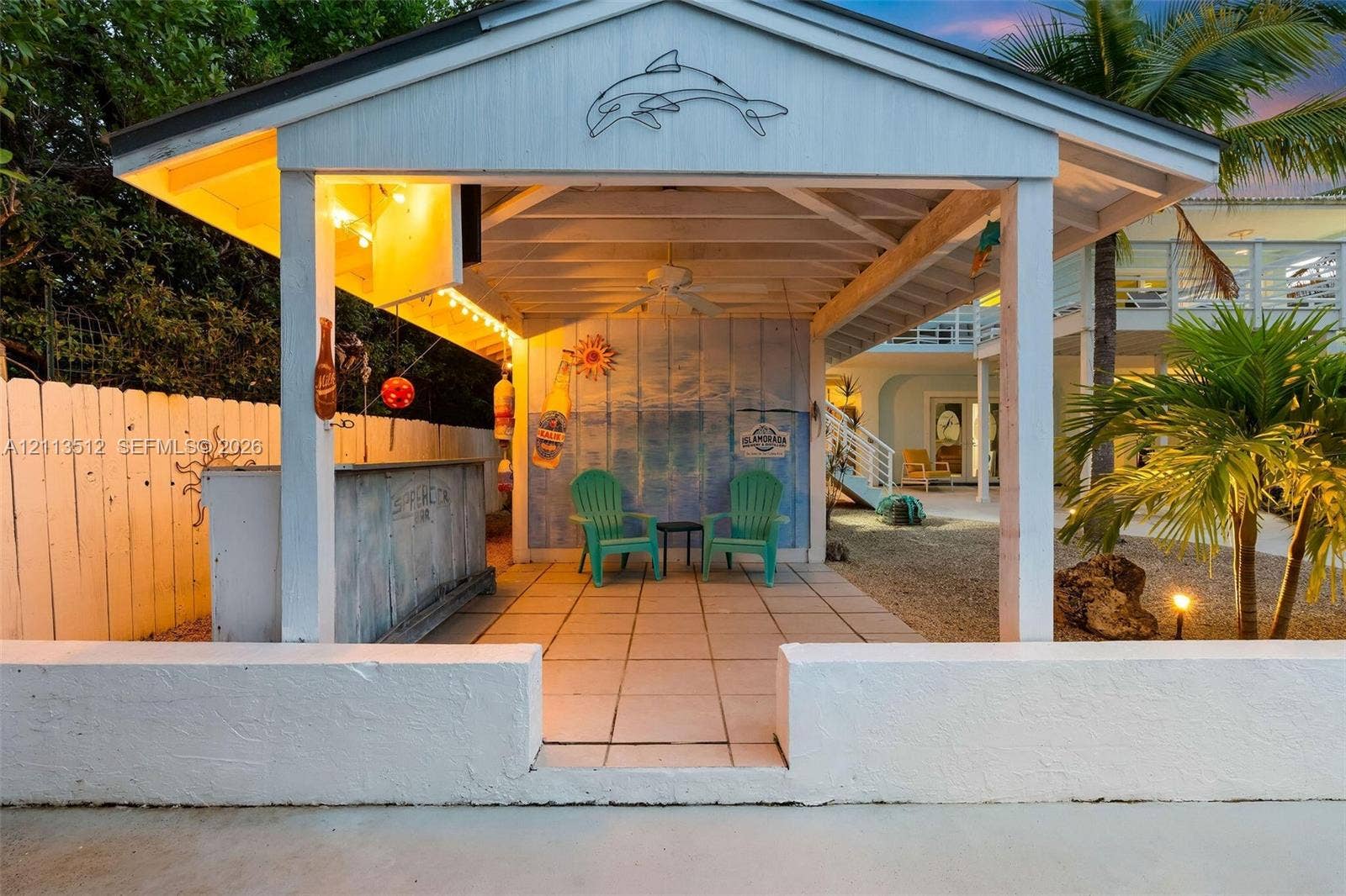 Key Largo, FL 33037 Covered outdoor pavilion featuring a built-in bar, tiled flooring, exposed beam ceiling with a mounted ceiling fan, and a low-profile perimeter masonry wall