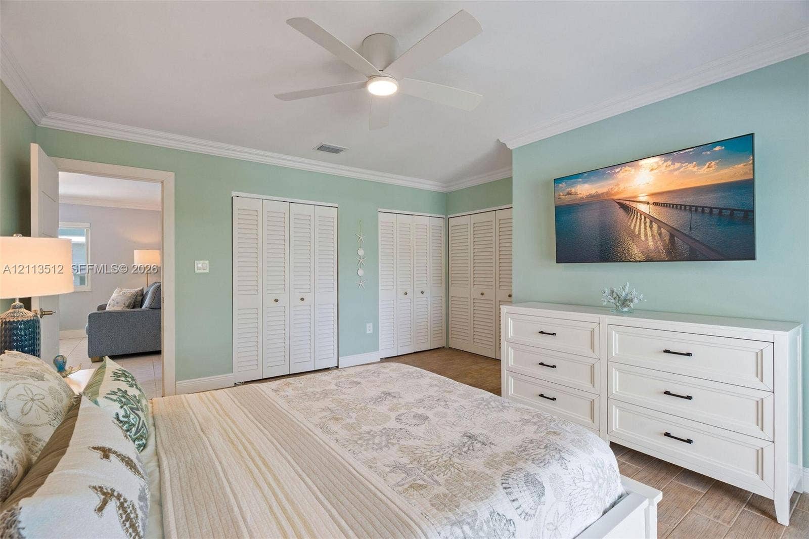 Key Largo, FL 33037 Neutral wall palette with crown molding, white louvered-style closet doors, and a ceiling-mounted light fixture with integrated fan blades
