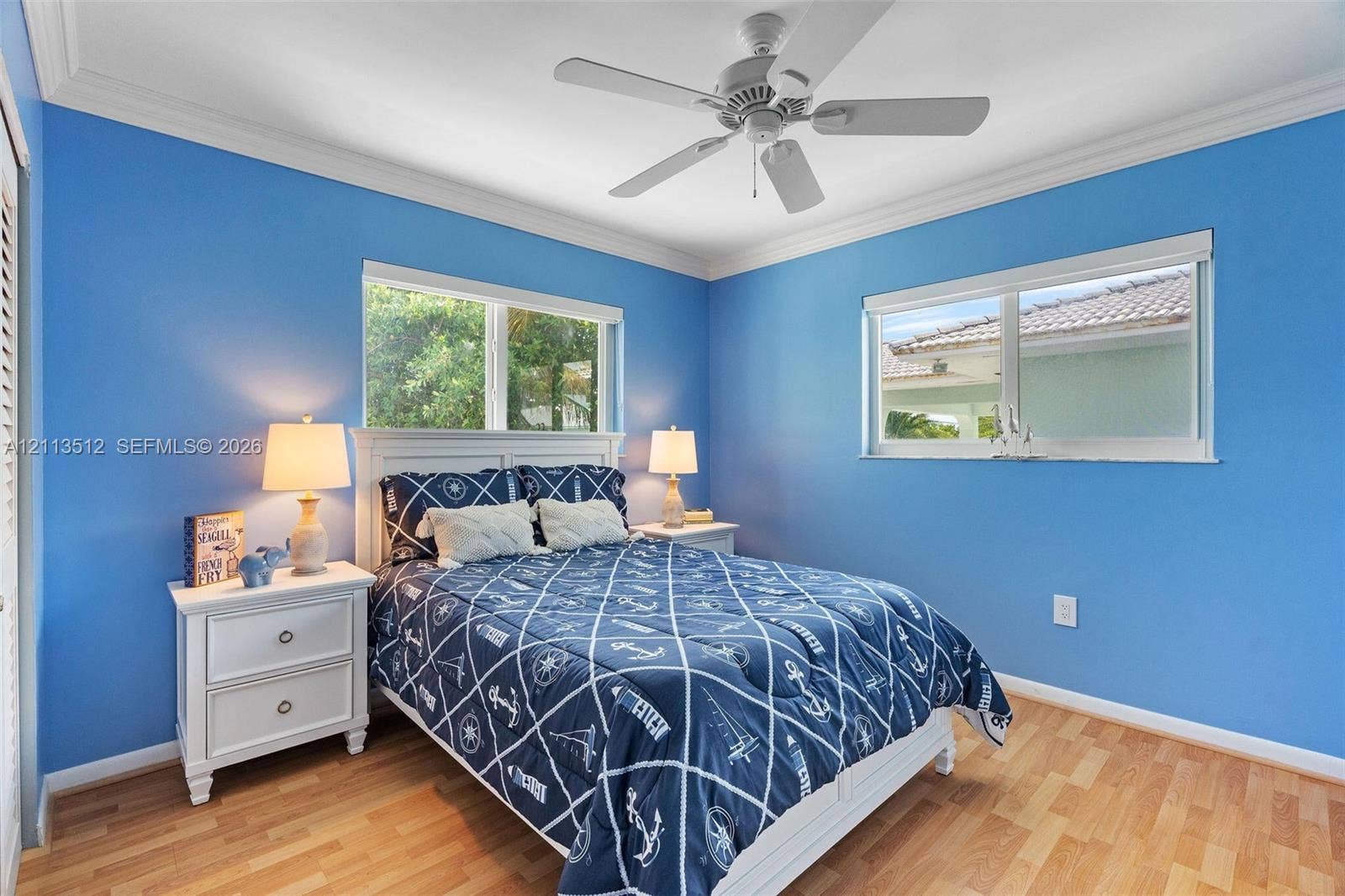 Key Largo, FL 33037 Wood-finish flooring, white ceiling fan, and crown molding