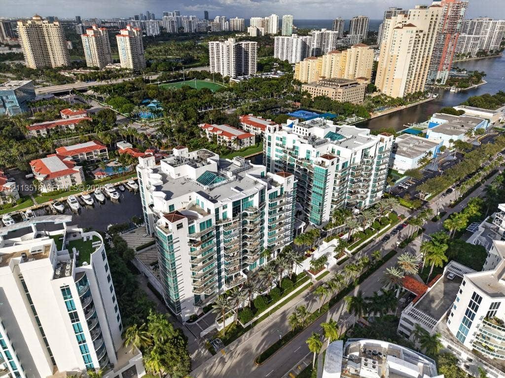 3131 NE 188th Street, #1-303, Aventura, FL 33180 High-rise residential complex featuring glass-paneled balconies, multi-story structural design, dedicated marina slips, and extensive perimeter landscaping