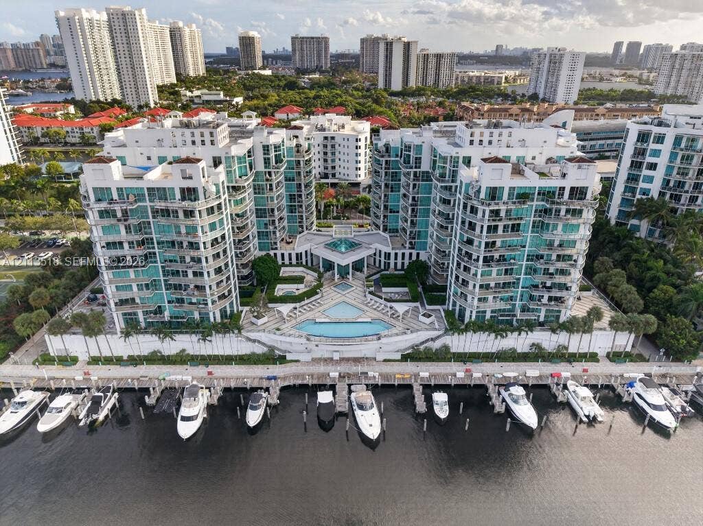 3131 NE 188th Street, #1-303, Aventura, FL 33180 Multi-story residential complex featuring private deep-water boat slips, expansive waterfront sun deck, tiered swimming pool, and glass-railed balconies