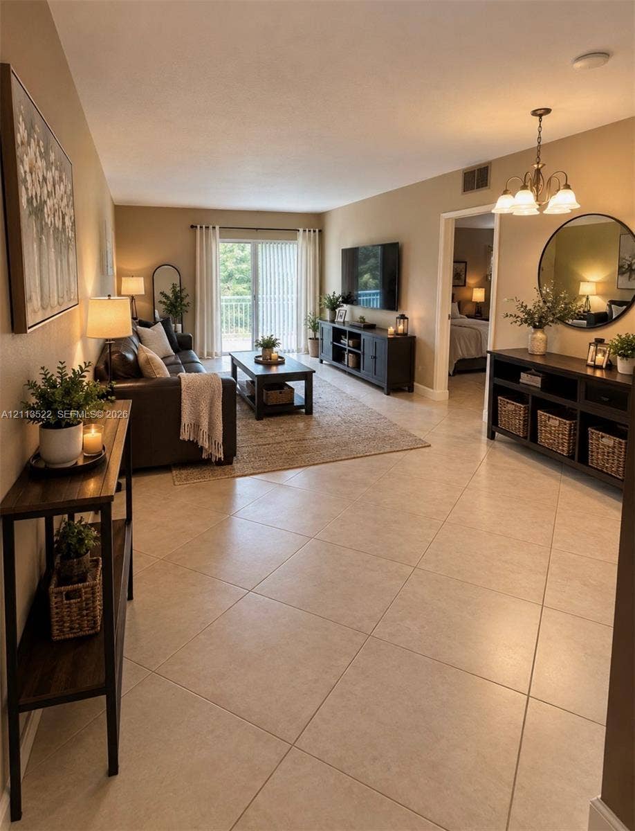 405 S Pine Island Road, #105D, Plantation, Plantation, FL 33324 Open-concept room featuring large-format neutral tile flooring, sliding glass doors, and a multi-arm overhead light fixture