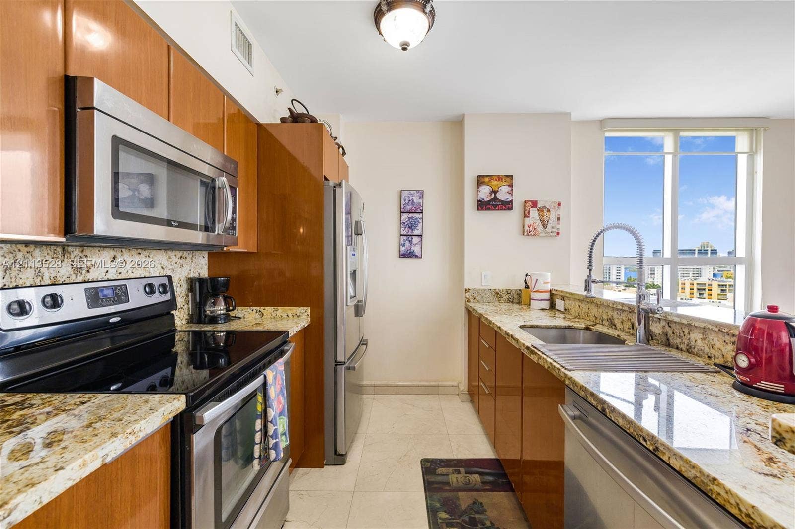 17555 Atlantic Boulevard, #1108, Sunny Isles Beach, Sunny Isles Beach, FL 33160 Kitchen featuring high-gloss cabinetry, stone countertops, stainless steel appliances, a high-arc pull-down faucet, and floor-to-ceiling windows