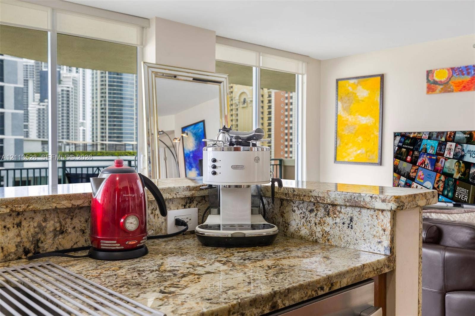 17555 Atlantic Boulevard, #1108, Sunny Isles Beach, Sunny Isles Beach, FL 33160 Kitchen featuring stone countertops with a breakfast bar, stainless steel appliance, and floor-to-ceiling windows