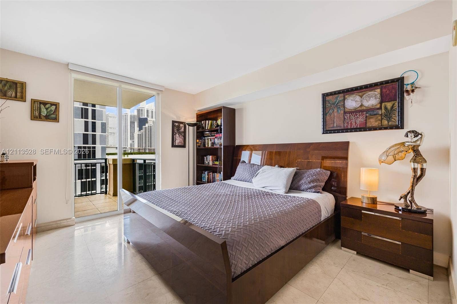 17555 Atlantic Boulevard, #1108, Sunny Isles Beach, Sunny Isles Beach, FL 33160 Interior space featuring light-toned tile flooring, built-in shelving, and a glass sliding door providing access to a private balcony
