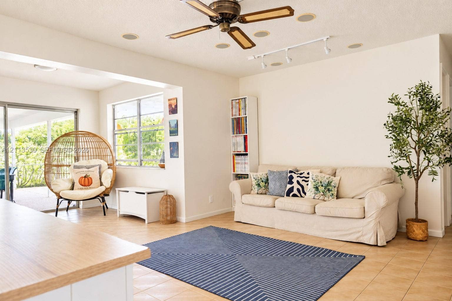 1773 NW 82nd Avenue, Coral Springs, FL 33071 Living area featuring tile flooring, ceiling fan, track lighting, built-in shelving, and sliding glass doors