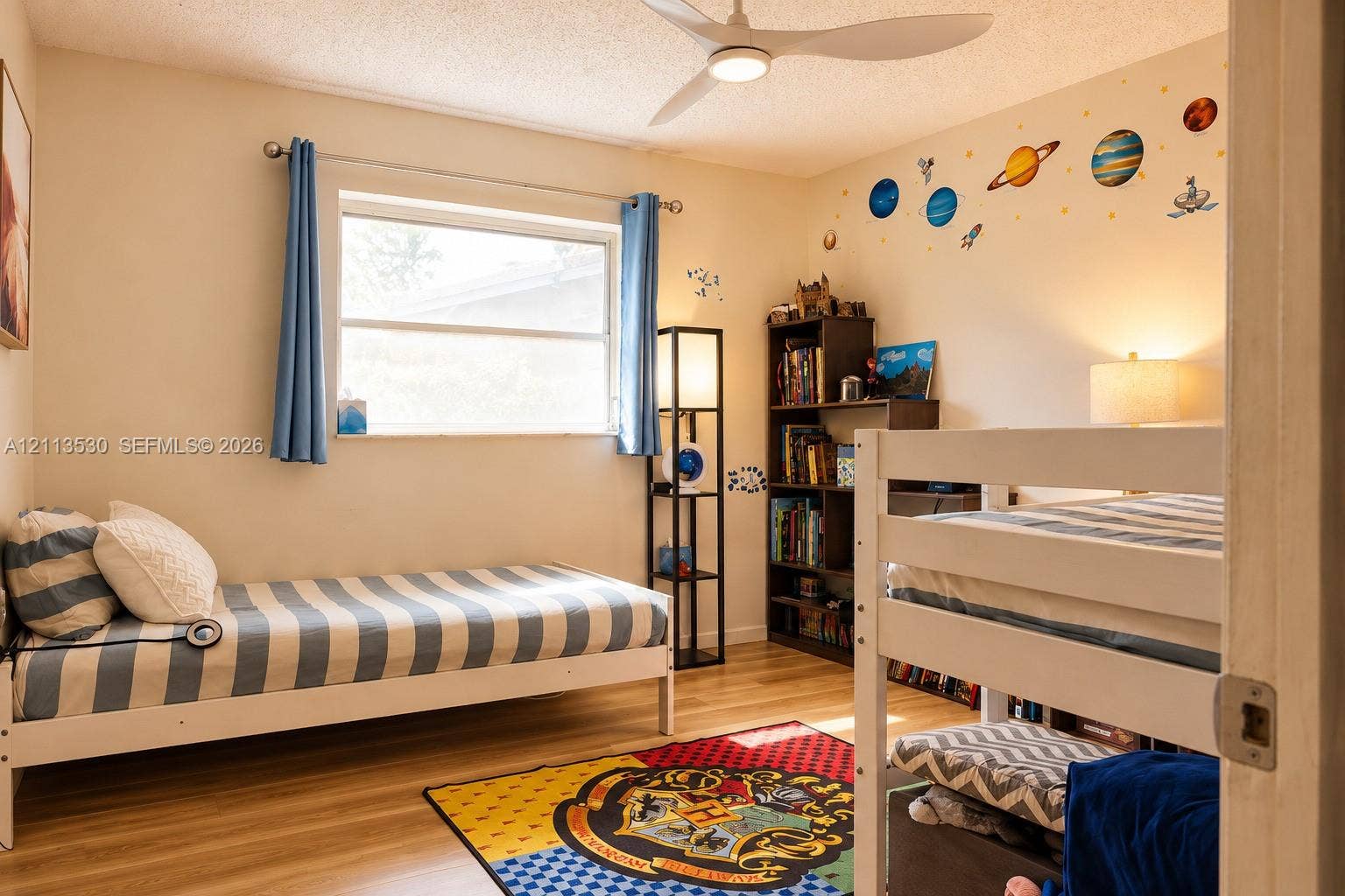 1773 NW 82nd Avenue, Coral Springs, FL 33071 Bedroom featuring wood-finish flooring, a white three-blade ceiling fan with integrated lighting, and a large window