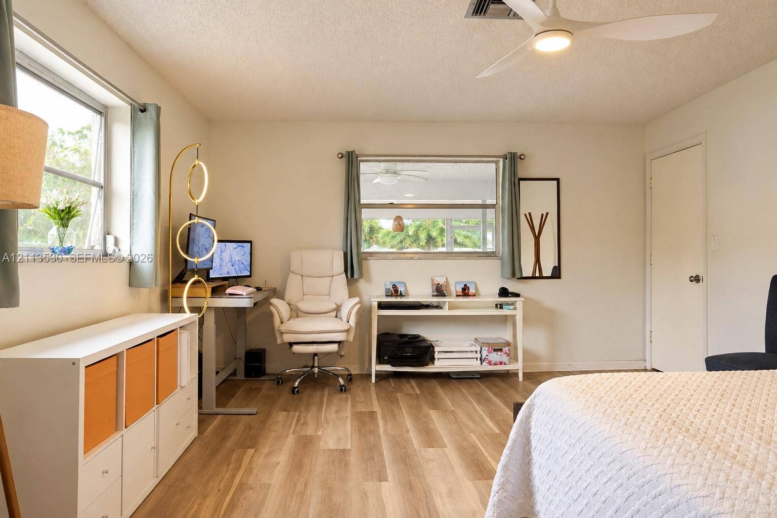 1773 NW 82nd Avenue, Coral Springs, FL 33071 Wood-finish flooring, white walls, dual windows with natural light, and a white ceiling fan with integrated lighting