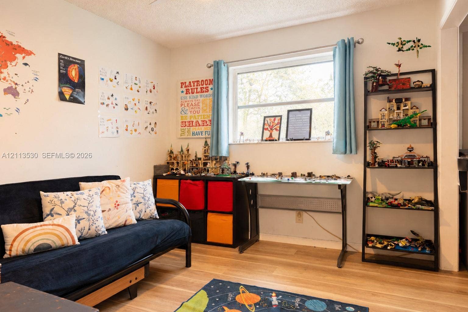 1773 NW 82nd Avenue, Coral Springs, FL 33071 Neutral-toned interior space featuring wood-finish flooring and a horizontal picture window with brushed nickel curtain rod hardware