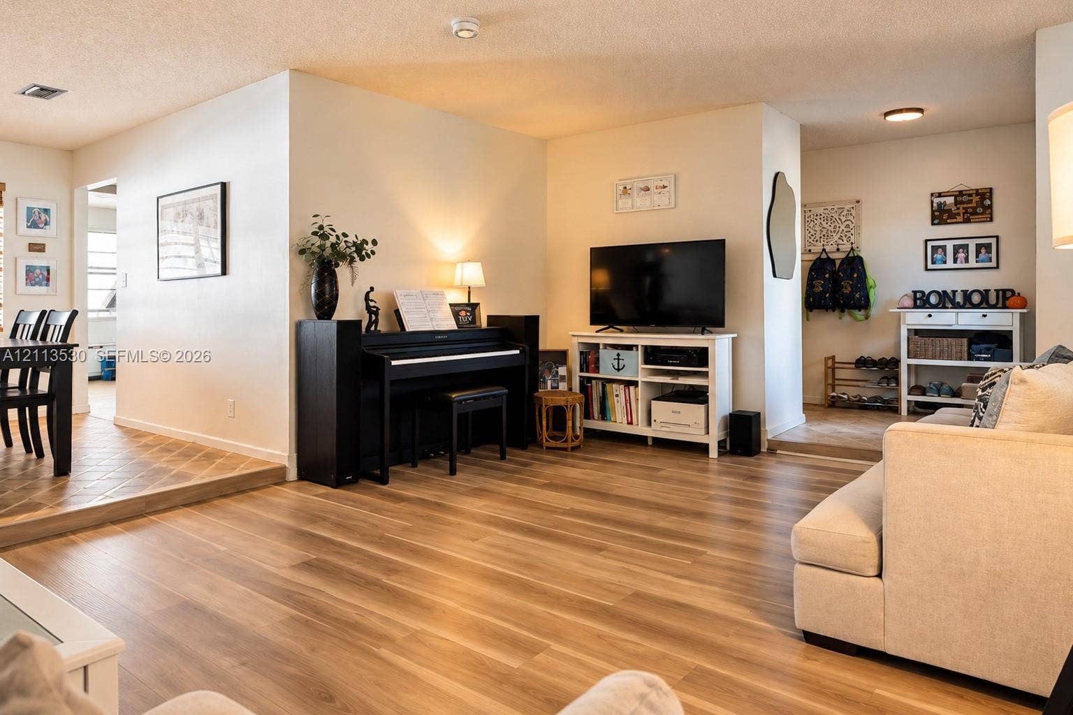 1773 NW 82nd Avenue, Coral Springs, FL 33071 Open-concept interior featuring wood-finish flooring, a step-down dining area with tiled flooring, and recessed ceiling lighting