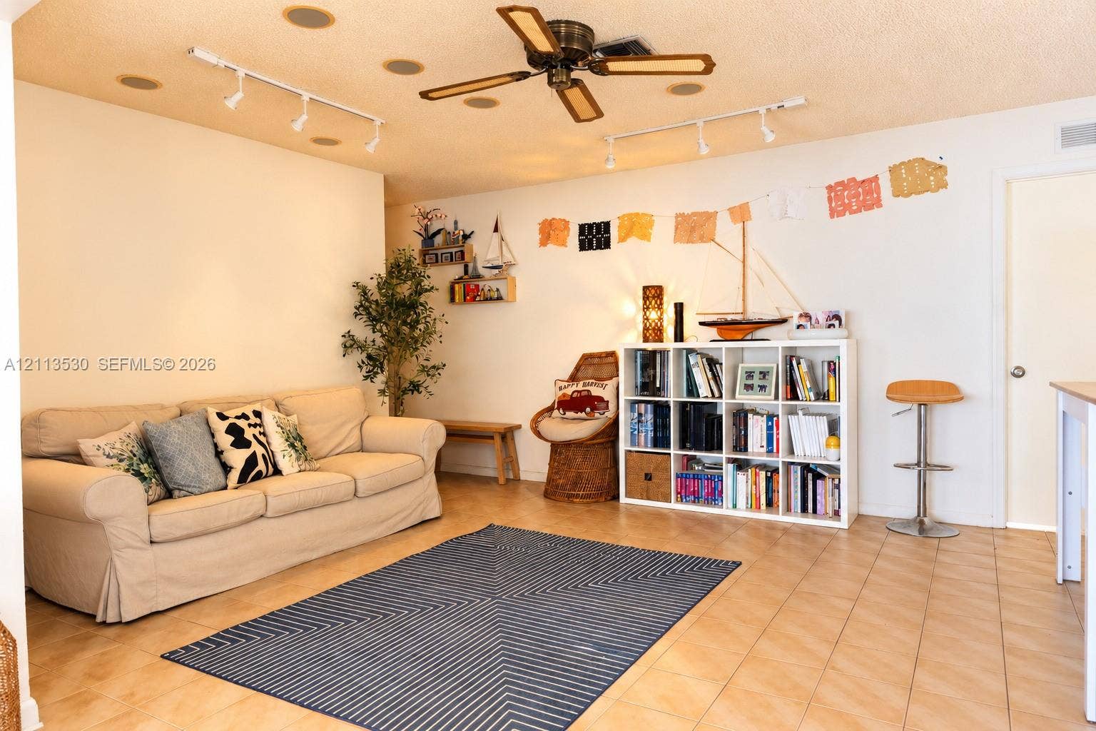 1773 NW 82nd Avenue, Coral Springs, FL 33071 Interior space featuring neutral tile flooring, multi-directional track lighting, and a multi-blade ceiling fan