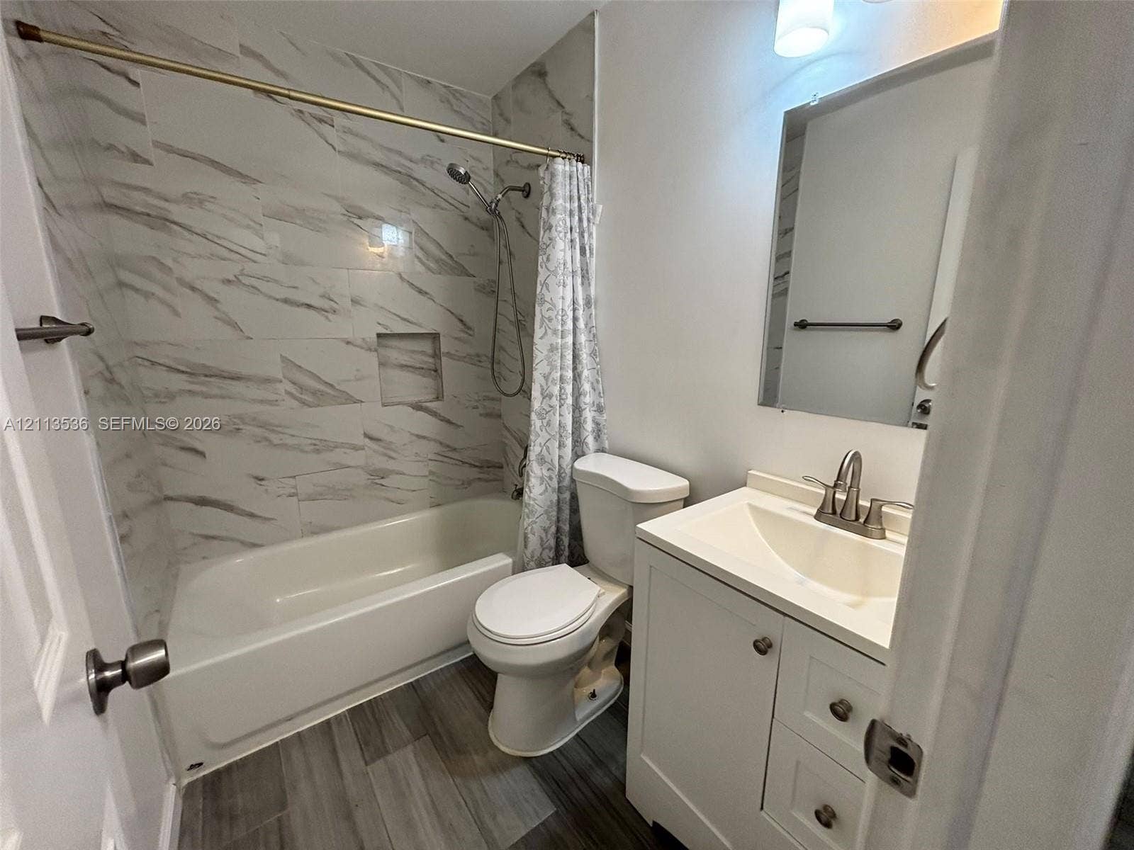 4840 SW 25th Avenue, #4840, Dania, Dania Beach, FL 33312 Bathroom featuring wood-finish flooring, white vanity with integrated basin, tub-shower combination with full-height stone-patterned tile surround, and built-in shower niche
