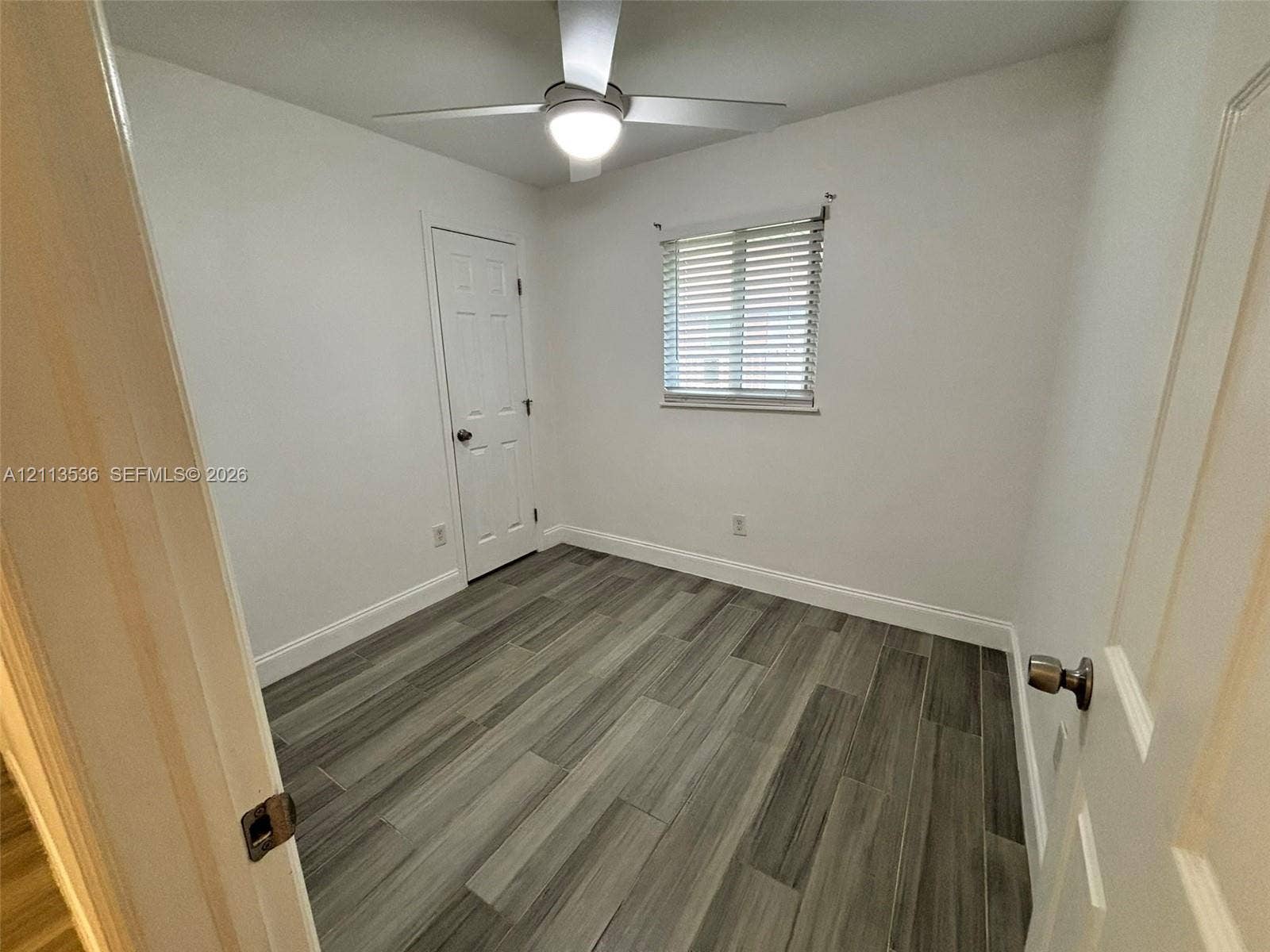 4840 SW 25th Avenue, #4840, Dania, Dania Beach, FL 33312 Room featuring wood-finish flooring, a ceiling-mounted light fixture with fan, and a single-panel interior door