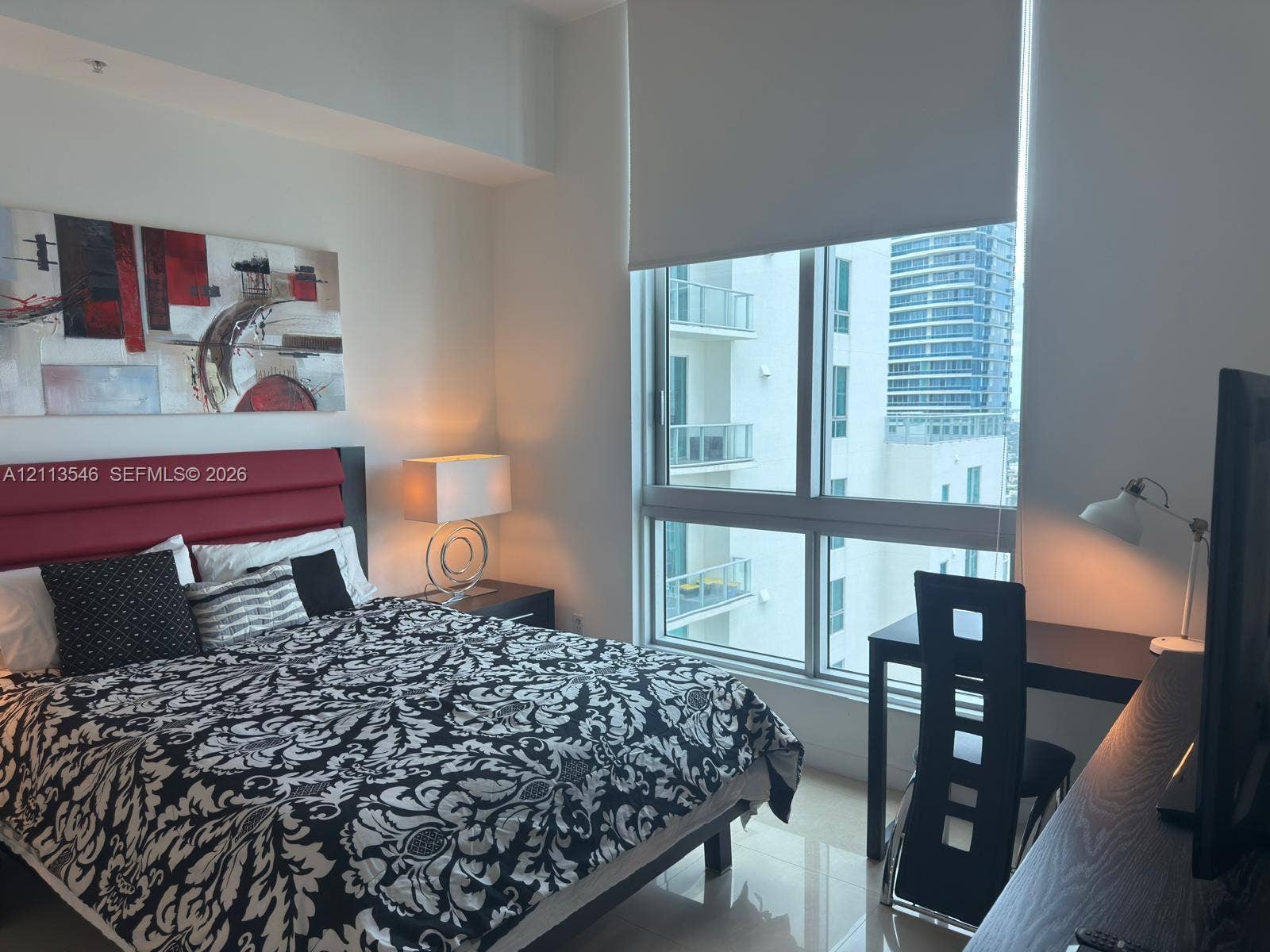 Floor-to-ceiling windows with roller shades and polished tile flooring
