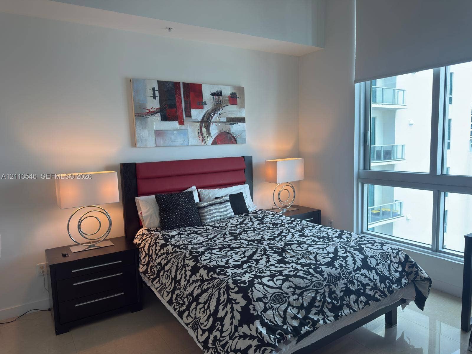 Floor-to-ceiling windows, high ceilings, and neutral tile flooring