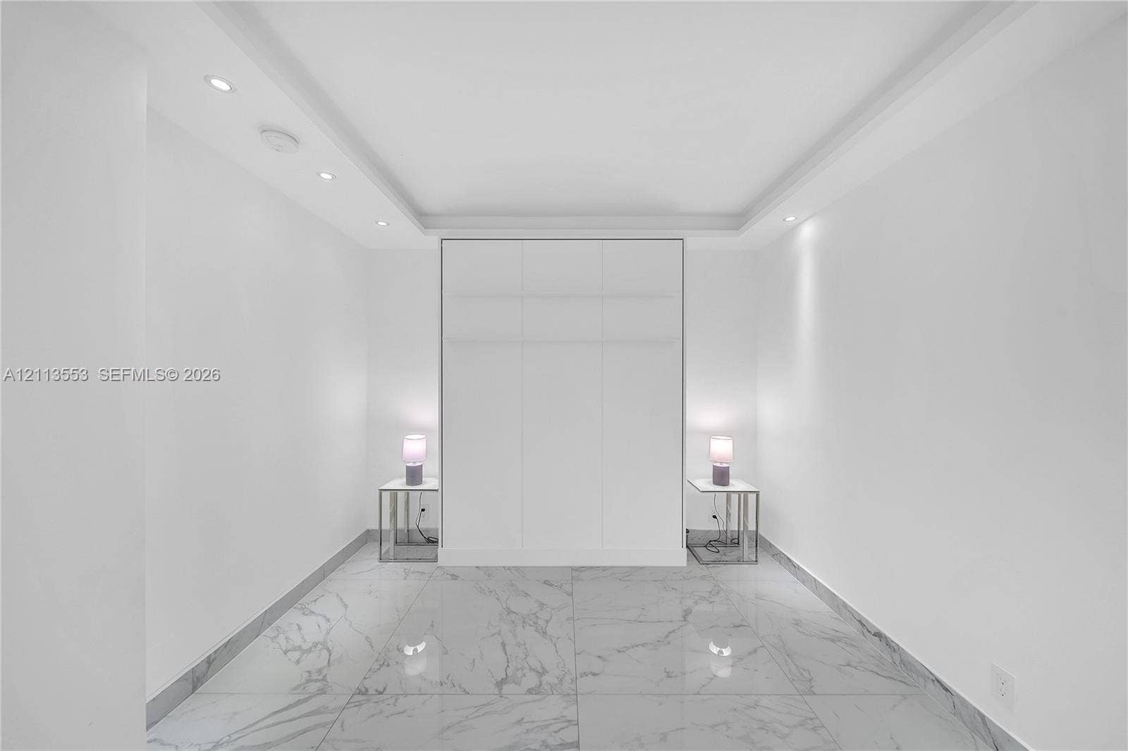 400 S Pointe Drive, #2106, Miami Beach, FL 33139 Large-format stone-look flooring, recessed ceiling lighting, tray ceiling architecture, and floor-to-ceiling built-in cabinetry