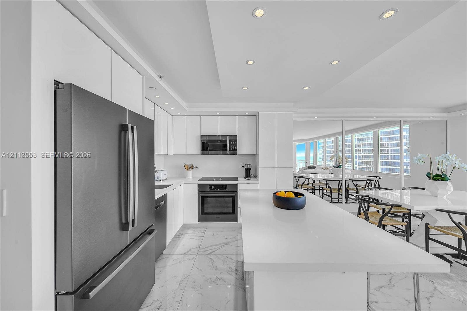 400 S Pointe Drive, #2106, Miami Beach, FL 33139 Kitchen featuring flat-panel white cabinetry, a center island with a stone-finish countertop, stone-finish flooring, recessed lighting, and stainless steel appliances