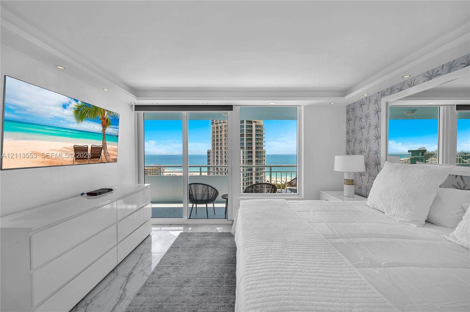 400 S Pointe Drive, #2106, Miami Beach, FL 33139 Sliding glass doors opening to a private balcony, large-format stone-finish flooring, recessed lighting, and expansive window wall