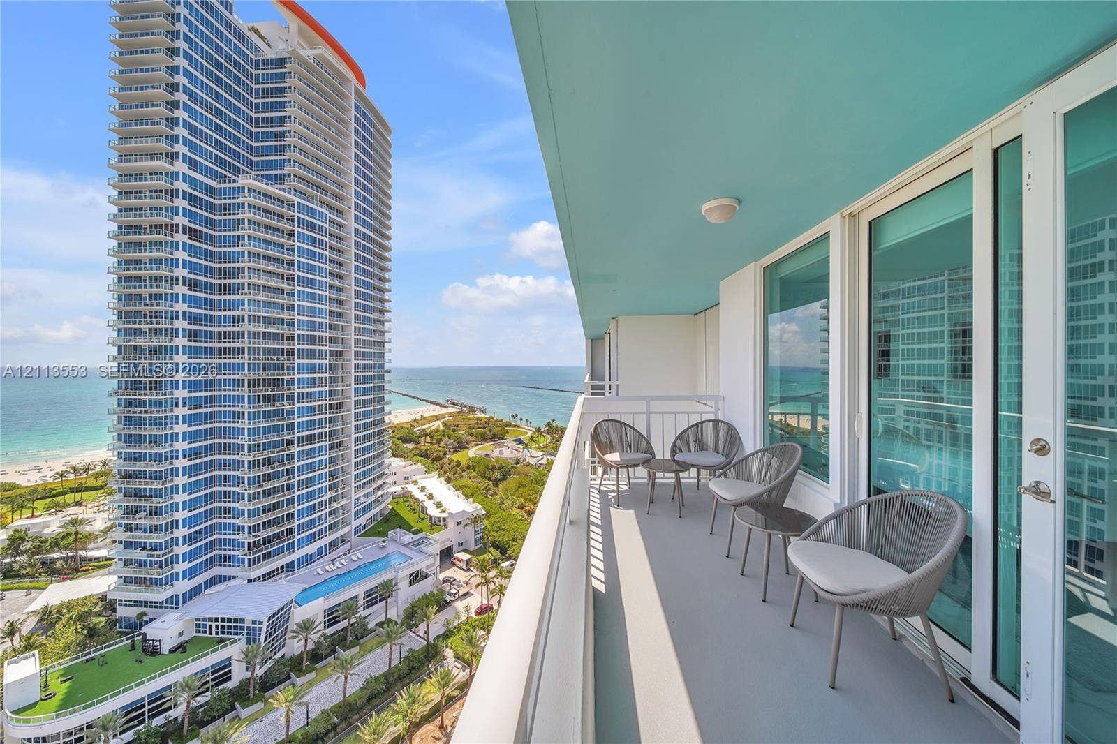 400 S Pointe Drive, #2106, Miami Beach, FL 33139 Covered balcony with a solid surface floor, white metal railing, and floor-to-ceiling glass sliding doors