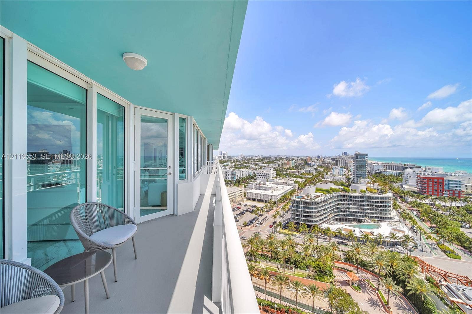 400 S Pointe Drive, #2106, Miami Beach, FL 33139 Wrap-around balcony featuring glass railing, neutral-toned flooring, and expansive exterior access through floor-to-ceiling glass paneled doors