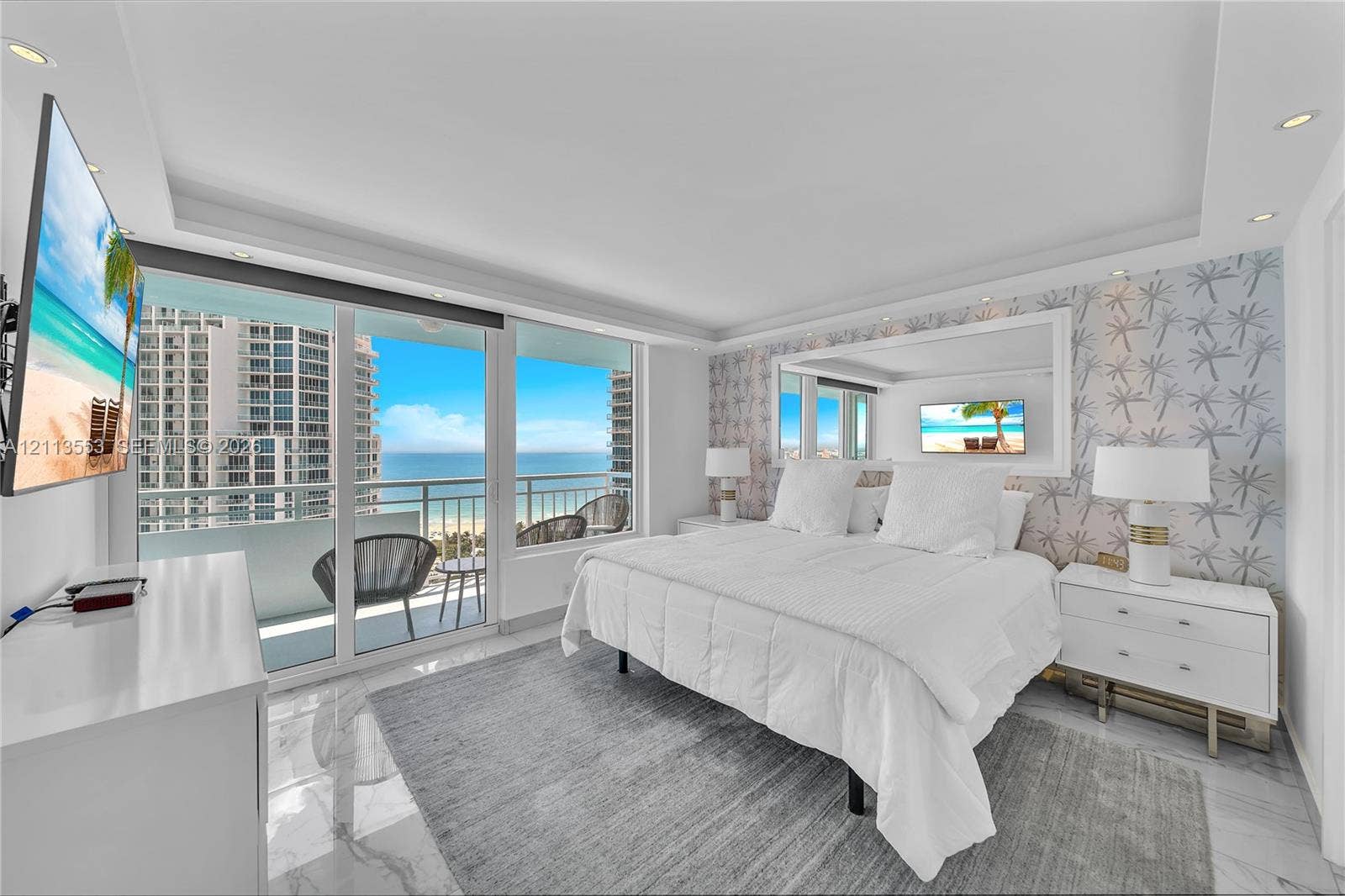 400 S Pointe Drive, #2106, Miami Beach, FL 33139 Floor-to-ceiling glass sliding doors, stone-finish flooring, recessed ceiling lighting, and expansive window wall with oceanic backdrop