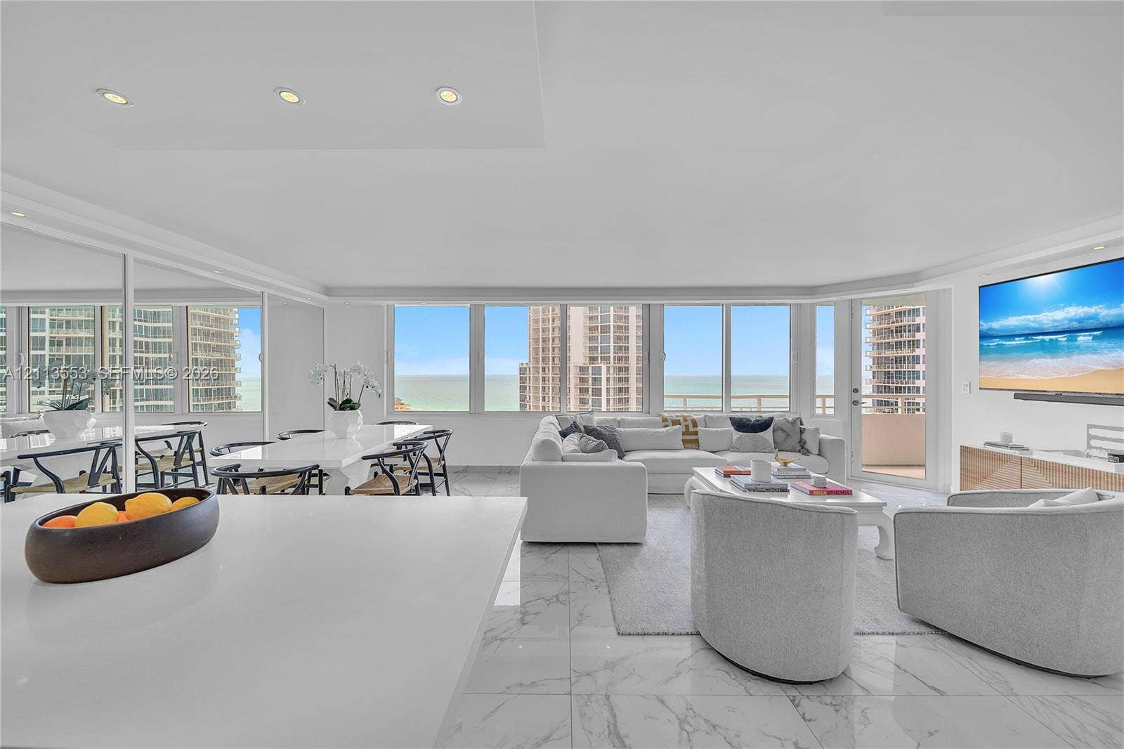 400 S Pointe Drive, #2106, Miami Beach, FL 33139 Open-concept living area featuring floor-to-ceiling windows, polished stone flooring, recessed lighting, and a private balcony