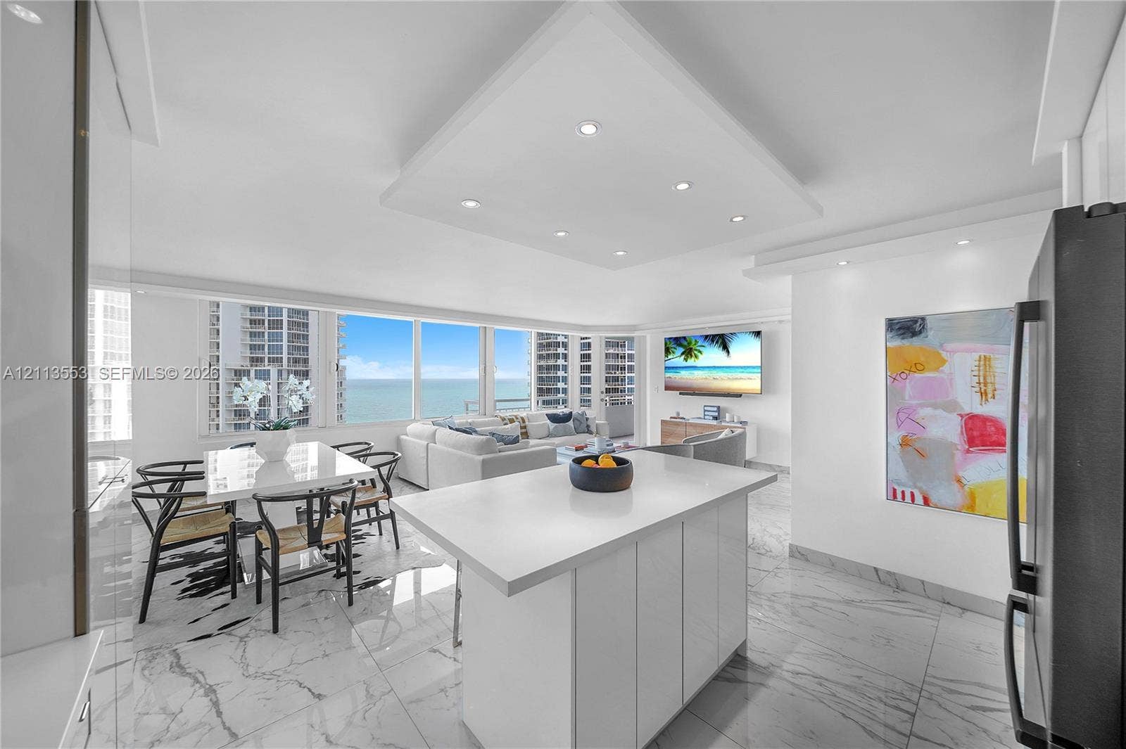 400 S Pointe Drive, #2106, Miami Beach, FL 33139 Open-concept space featuring expansive floor-to-ceiling windows, white cabinetry, a center island with a stone-finish countertop, and polished flooring with a marble-style pattern