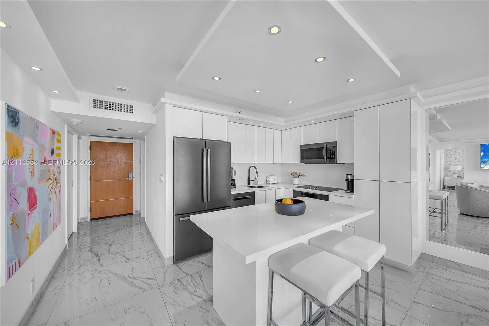 400 S Pointe Drive, #2106, Miami Beach, FL 33139 Modern kitchen featuring flat-panel white cabinetry, a center island with a quartz countertop, recessed ceiling lighting, and tile flooring with a stone-finish pattern