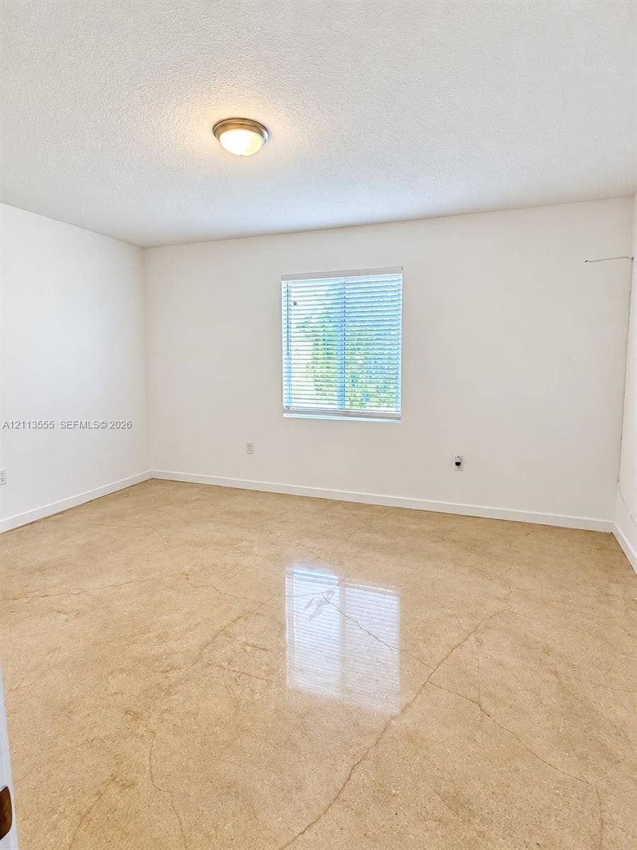 104 NW 31st Avenue, Fort Lauderdale, Fort Lauderdale, FL 33311 Neutral interior space featuring polished concrete flooring, white walls, and a single-light flush-mount ceiling fixture with an integrated window blind
