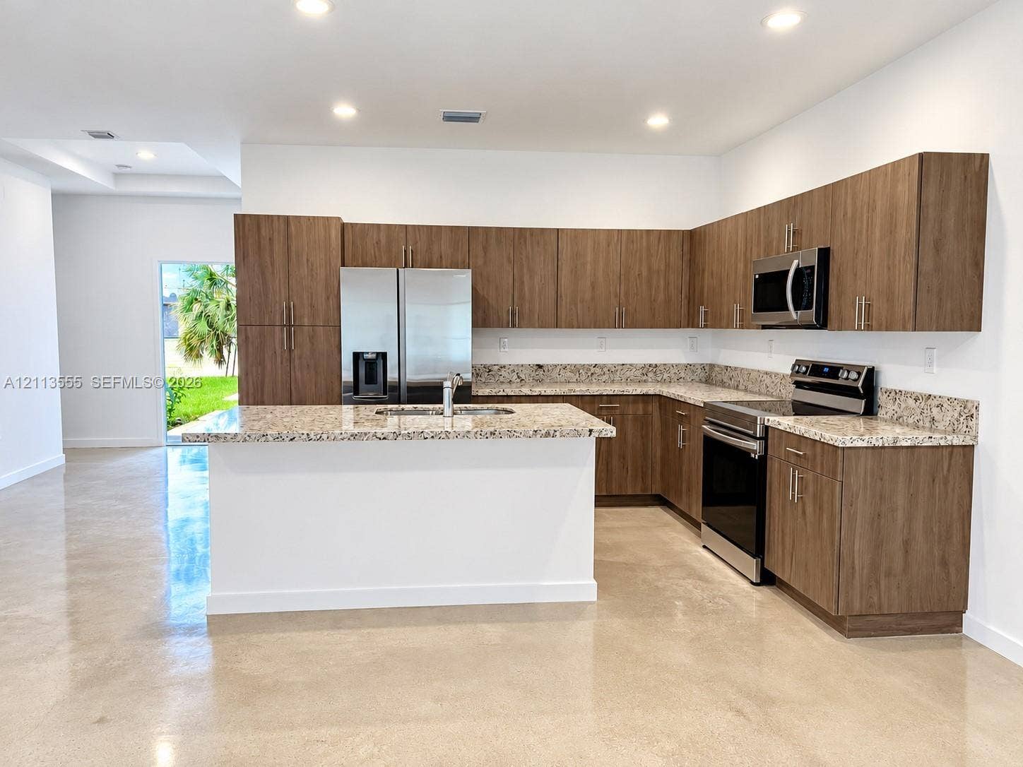 104 NW 31st Avenue, Fort Lauderdale, Fort Lauderdale, FL 33311 Kitchen featuring wood-finish cabinetry, stone-surface countertops, center island with integrated sink, stainless steel appliances, and polished concrete flooring