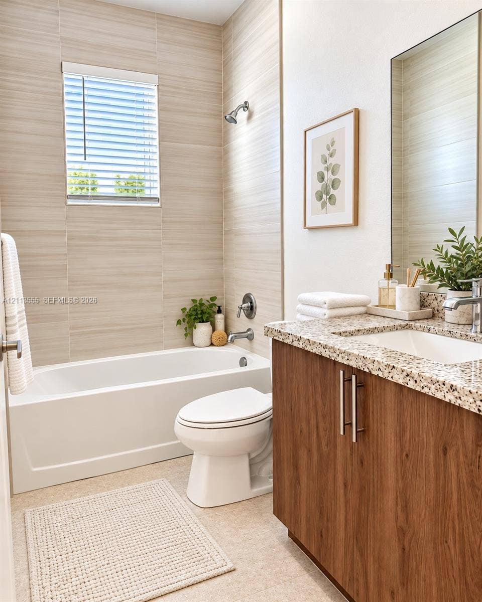104 NW 31st Avenue, Fort Lauderdale, Fort Lauderdale, FL 33311 Bathroom featuring floor-to-ceiling textured tile surround, built-in vanity with wood-finish cabinetry, stone-composite countertop with integrated sink, and an inset mirror