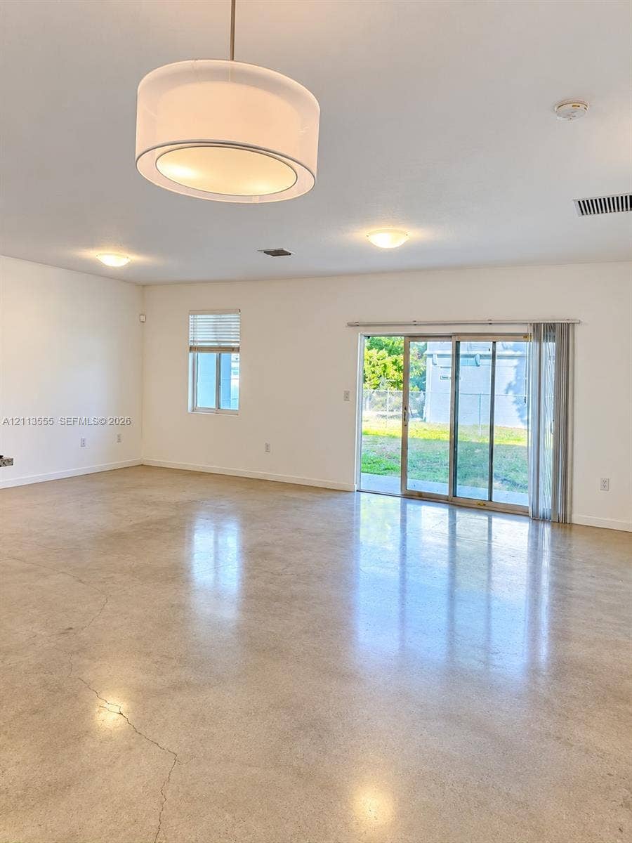104 NW 31st Avenue, Fort Lauderdale, Fort Lauderdale, FL 33311 Polished concrete flooring, drum-style pendant lighting, recessed ceiling lights, and a sliding glass door providing access to the exterior