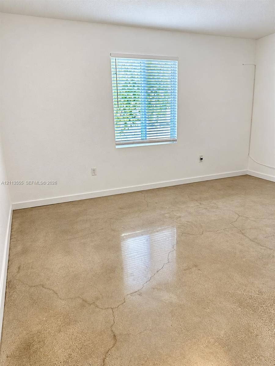 104 NW 31st Avenue, Fort Lauderdale, Fort Lauderdale, FL 33311 Polished concrete flooring, neutral wall finishes, and a single-pane window with installed horizontal blinds