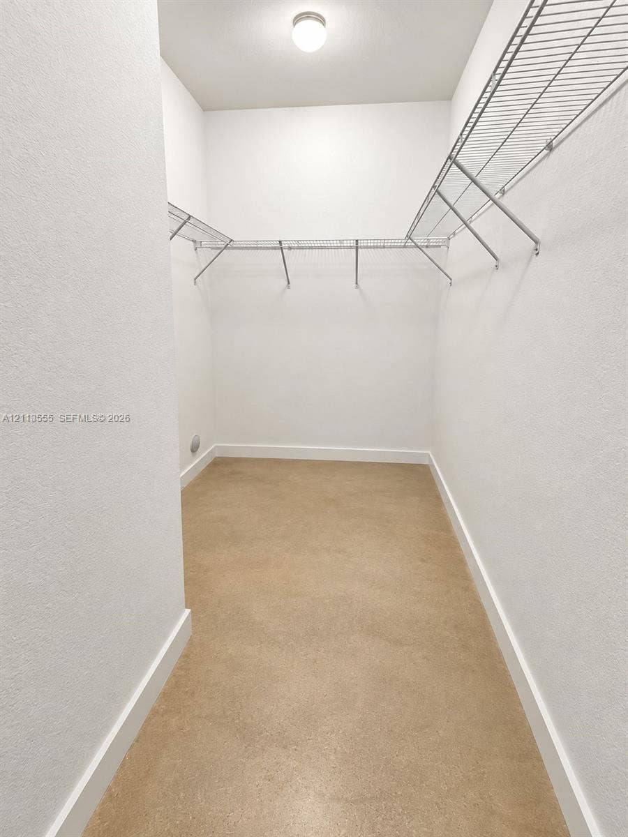 104 NW 31st Avenue, Fort Lauderdale, Fort Lauderdale, FL 33311 Walk-in closet featuring neutral walls, wire shelving, a ceiling-mounted light fixture, and solid-surface flooring