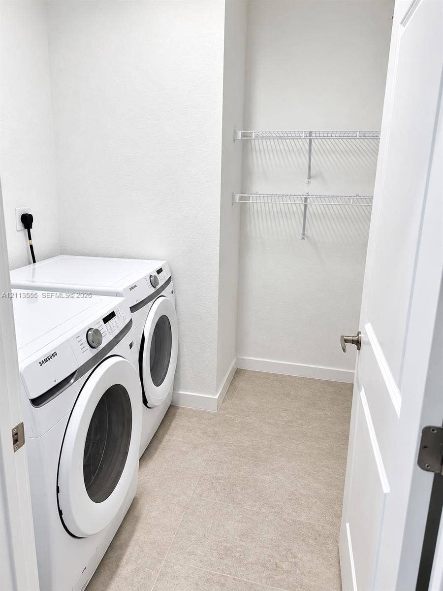 104 NW 31st Avenue, Fort Lauderdale, Fort Lauderdale, FL 33311 Laundry room featuring tile flooring, white interior walls, and dual-tier wire shelving