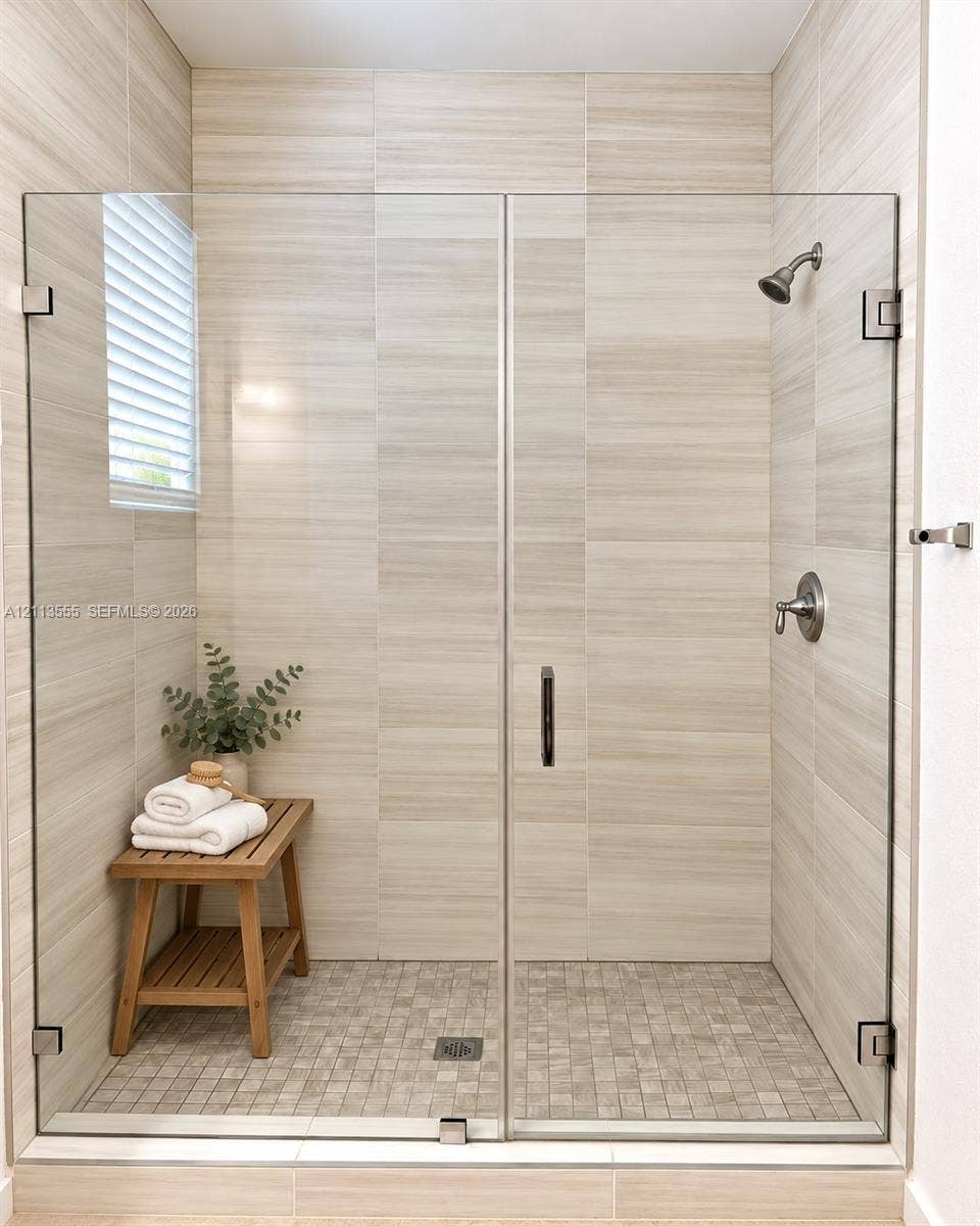 104 NW 31st Avenue, Fort Lauderdale, Fort Lauderdale, FL 33311 Walk-in shower featuring floor-to-ceiling large-format tile walls, mosaic tile flooring, a frameless glass enclosure, and brushed nickel hardware
