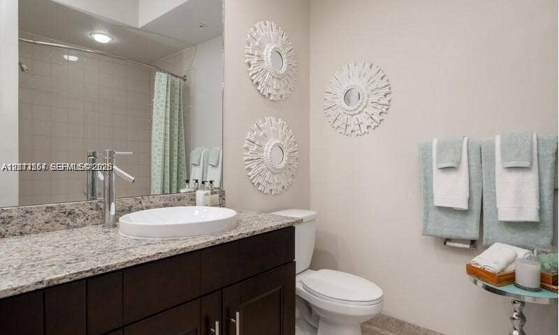 320 Franklin Club Drive, #Boca 1, Delray Beach, Delray Beach, FL 33483 Dark wood-finish vanity with a stone countertop, vessel sink, polished chrome faucet, and full-wall mirror