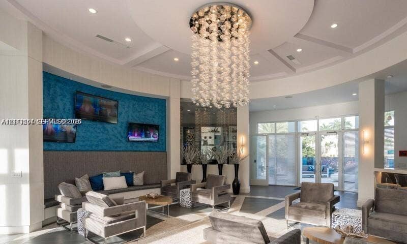 320 Franklin Club Drive, #Boca 1, Delray Beach, Delray Beach, FL 33483 Circular rotunda ceiling featuring recessed lighting and a tiered glass-sphere chandelier, textured blue accent wall, polished stone flooring with geometric inlays, and floor-to-ceiling glass panel doors