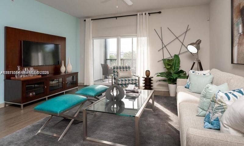 320 Franklin Club Drive, #Boca 1, Delray Beach, Delray Beach, FL 33483 Living area featuring wood-finish flooring, a built-in wood-veneer media wall, a ceiling fan, and sliding glass doors with access to a balcony