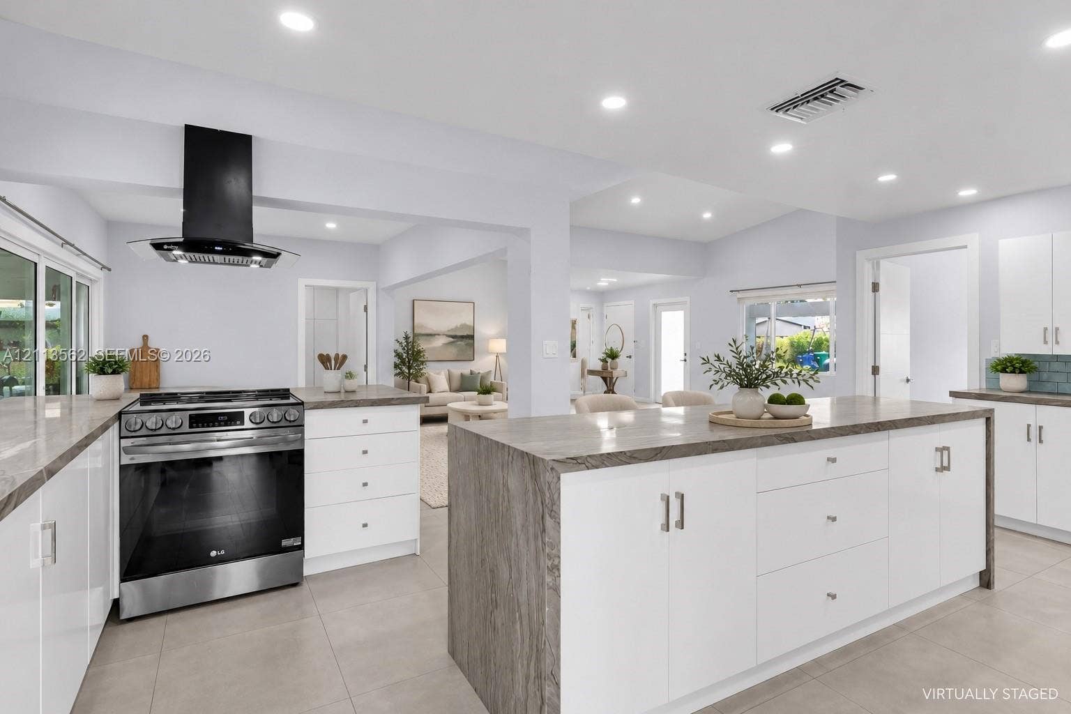 Kitchen featuring white cabinetry, stone-surface countertops, center island, stainless steel slide-in range, and a wall-mounted range hood