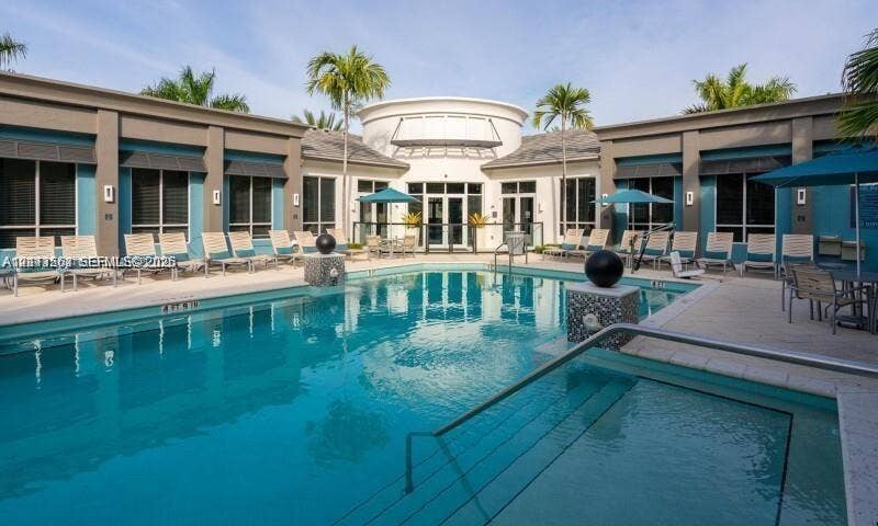 320 Franklin Club Drive, #Boynton, Delray Beach, Delray Beach, FL 33483 Swimming pool and spa area with a stone-accented water feature, sun deck, and mature palm trees