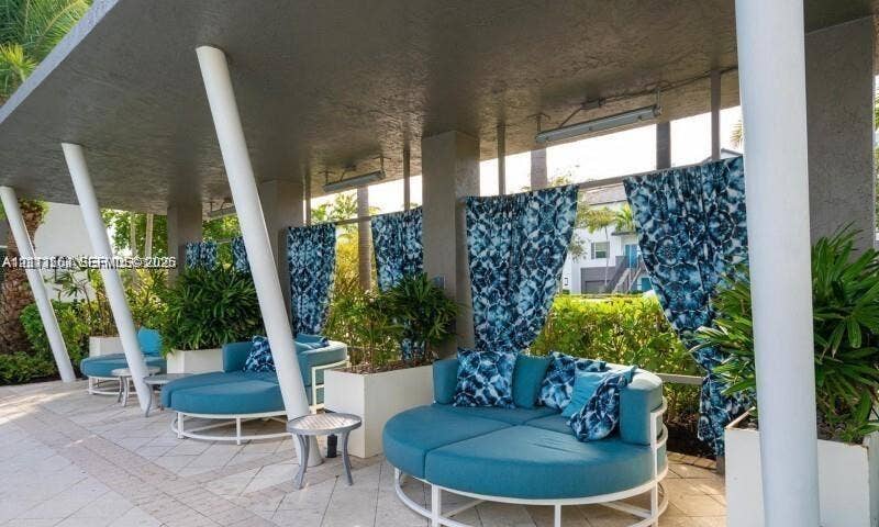 320 Franklin Club Drive, #Boynton, Delray Beach, Delray Beach, FL 33483 Covered outdoor lounge area featuring stone tile flooring, structural white pillars, overhead mounted lighting, and integrated planters
