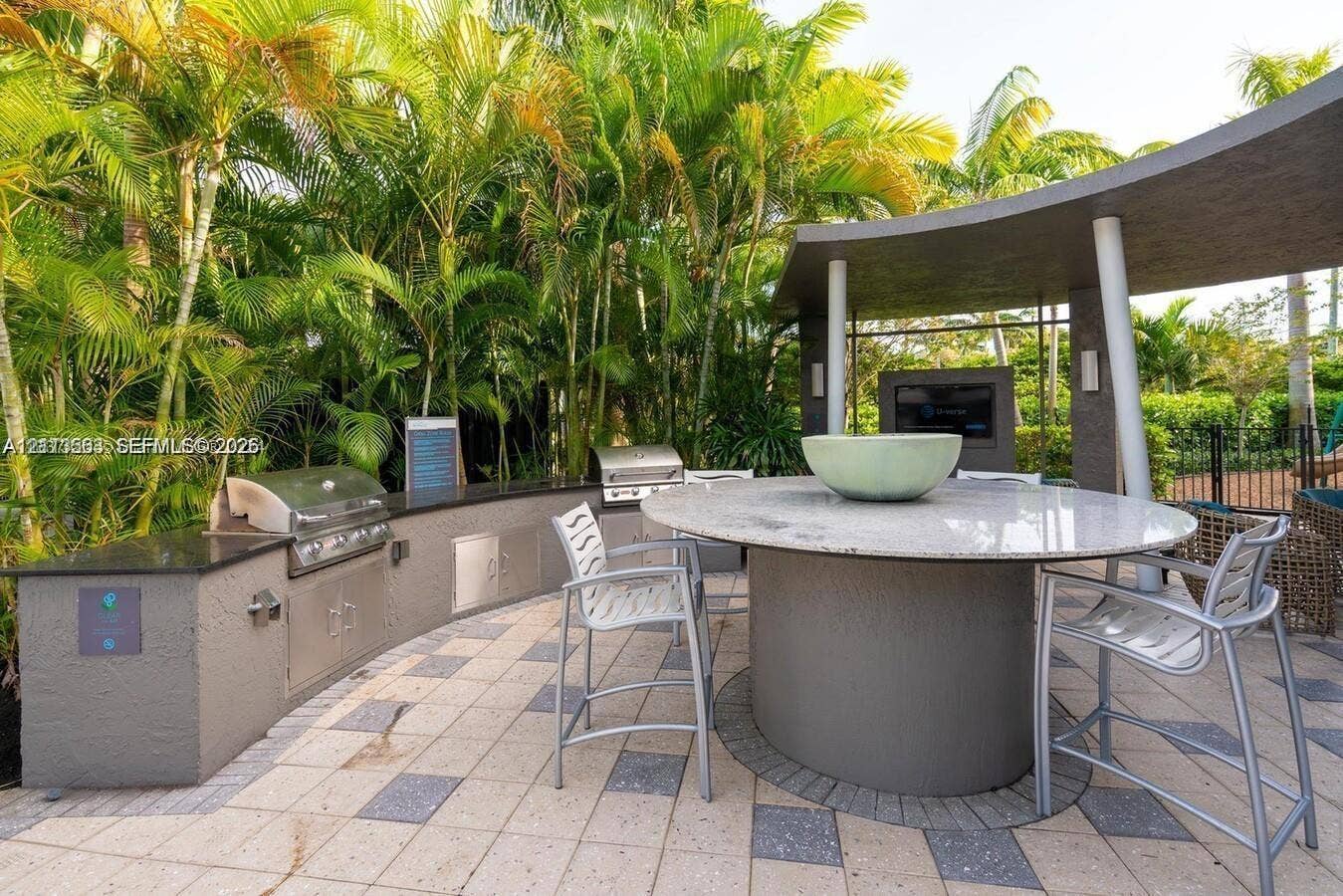 320 Franklin Club Drive, #Boynton, Delray Beach, Delray Beach, FL 33483 Outdoor kitchen featuring a built-in stainless steel grill, stone-surfaced prep counters, integrated cabinetry, a circular stone-topped island, and a covered patio structure