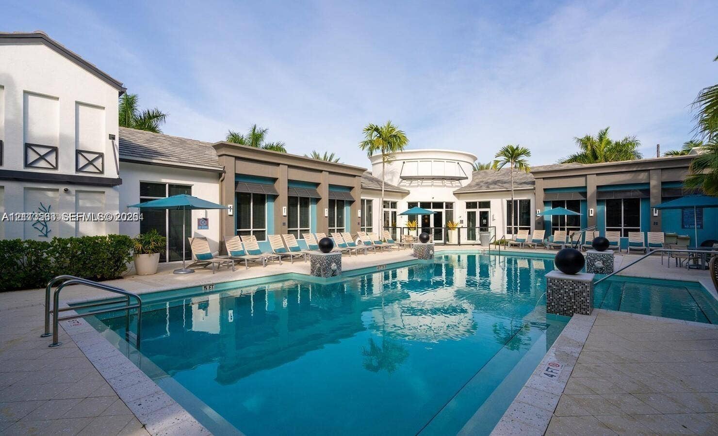 320 Franklin Club Drive, #Boynton, Delray Beach, Delray Beach, FL 33483 Swimming pool with tiled coping, stone-accented columns, paved pool deck, and surrounding multi-structure exterior