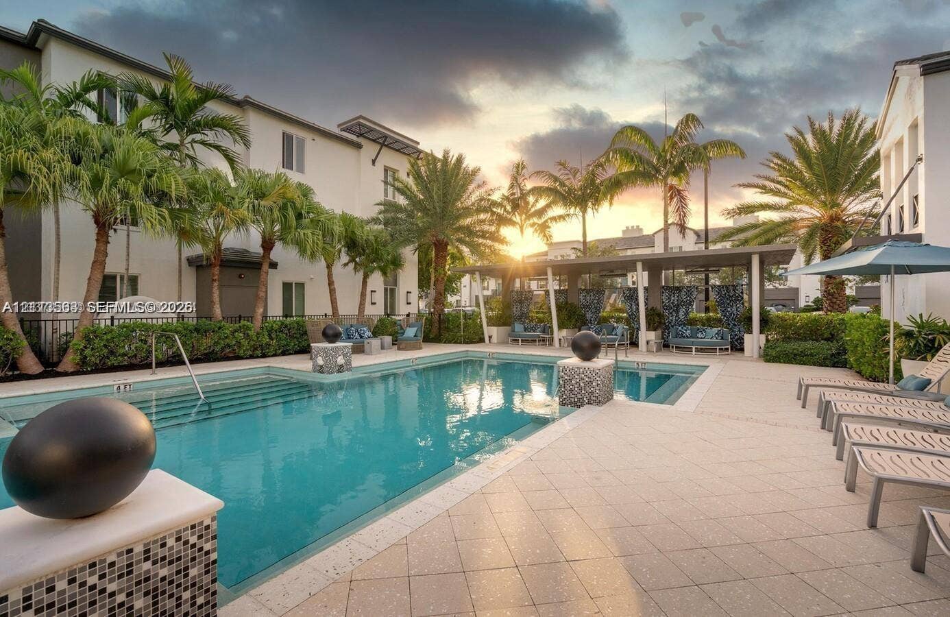 320 Franklin Club Drive, #Boynton, Delray Beach, Delray Beach, FL 33483 In-ground swimming pool featuring built-in entry steps, tile surround, stone-tiled decorative pillars, covered patio area, and mature palm landscaping