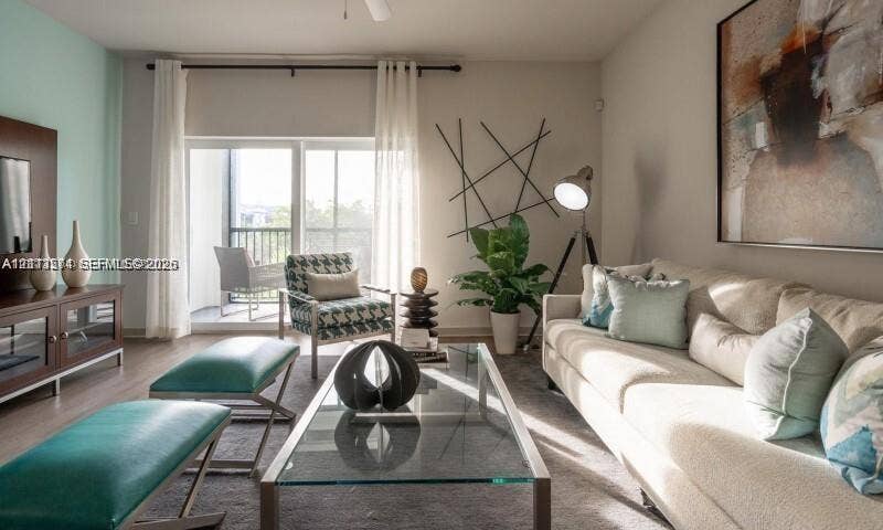 320 Franklin Club Drive, #Lantana, Delray Beach, Delray Beach, FL 33483 Living area featuring wood-finish flooring, a wall-mounted media console, and sliding glass doors with direct access to a private balcony