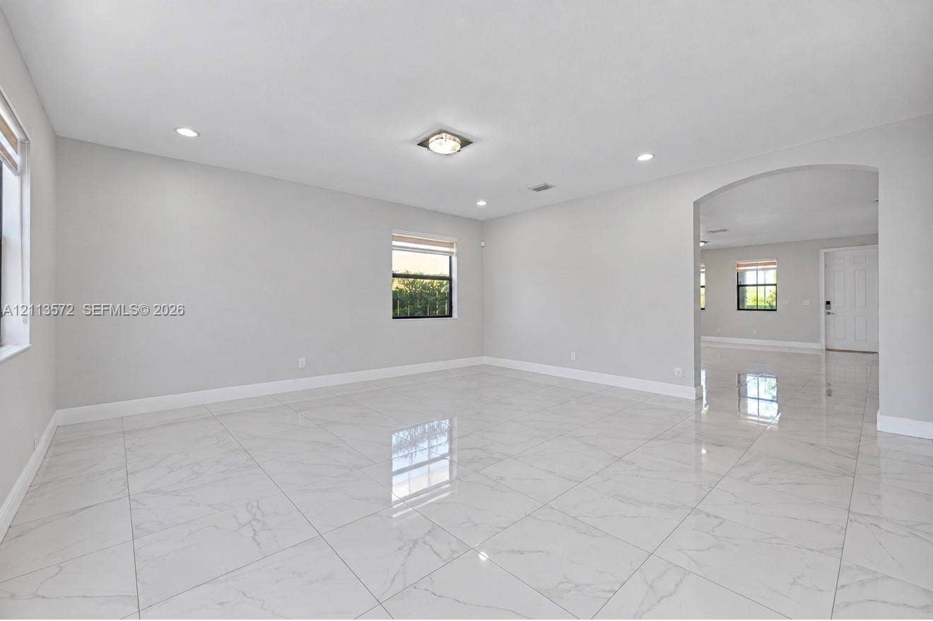9860 NW 86th Terrace, Doral, FL 33178 Large-format tile flooring, recessed lighting, archway architectural detailing, and neutral wall tones