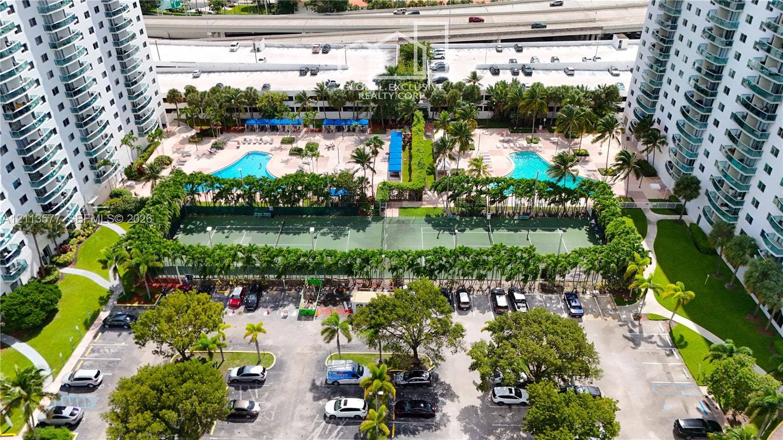 19370 Collins Avenue, #1622, Sunny Isles Beach, FL 33160 High-rise community featuring dual outdoor swimming pools, multi-court tennis facilities, paved parking, and landscaped grounds